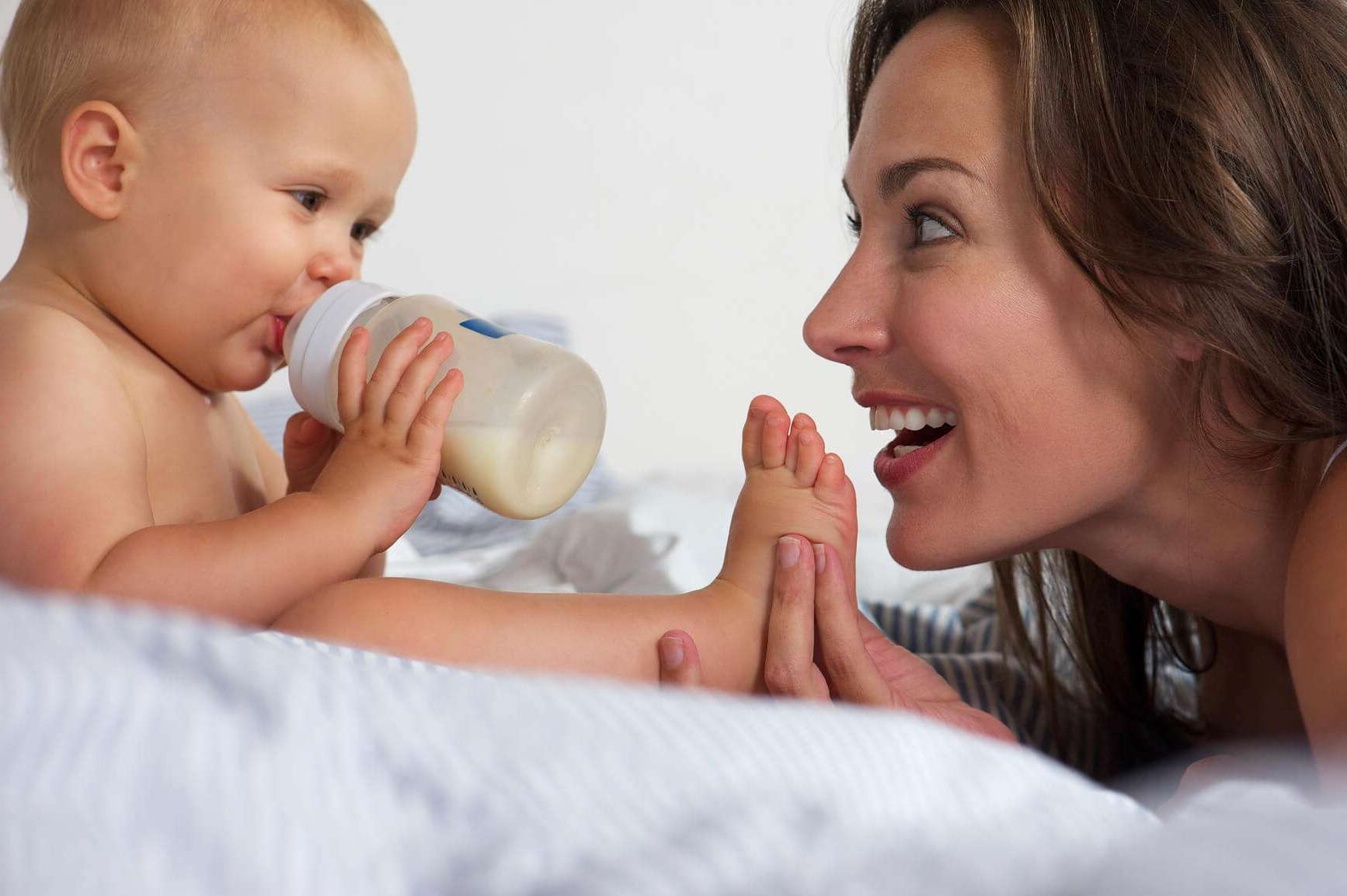 Кормление ребенка. Молоко матери. Мама кормит ребенка. Мама и малыш с бутылочкой.
