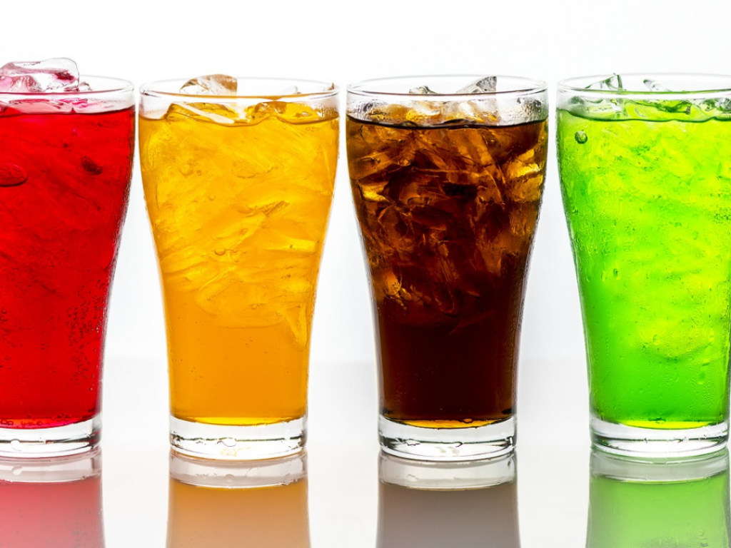 Газированная сладкая вода разных цветов в стаканах со льдом