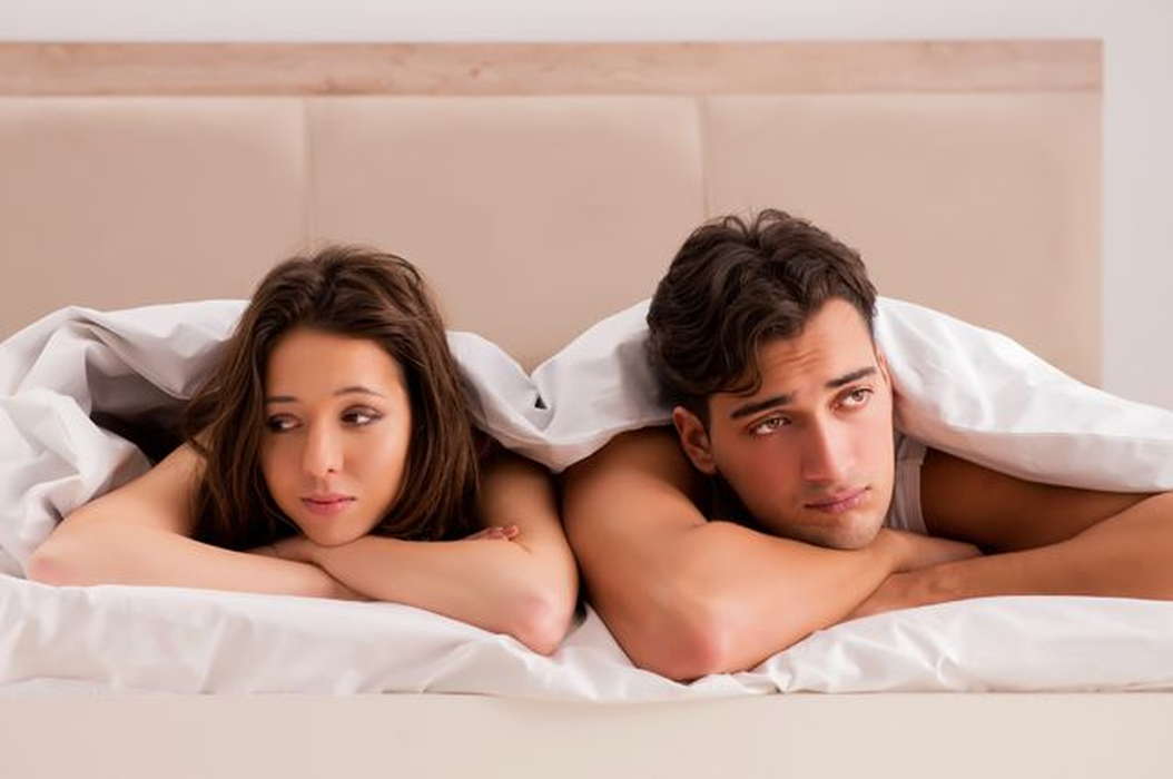 Семейная интимная жизнь: муж и жена в кровати под одеялом