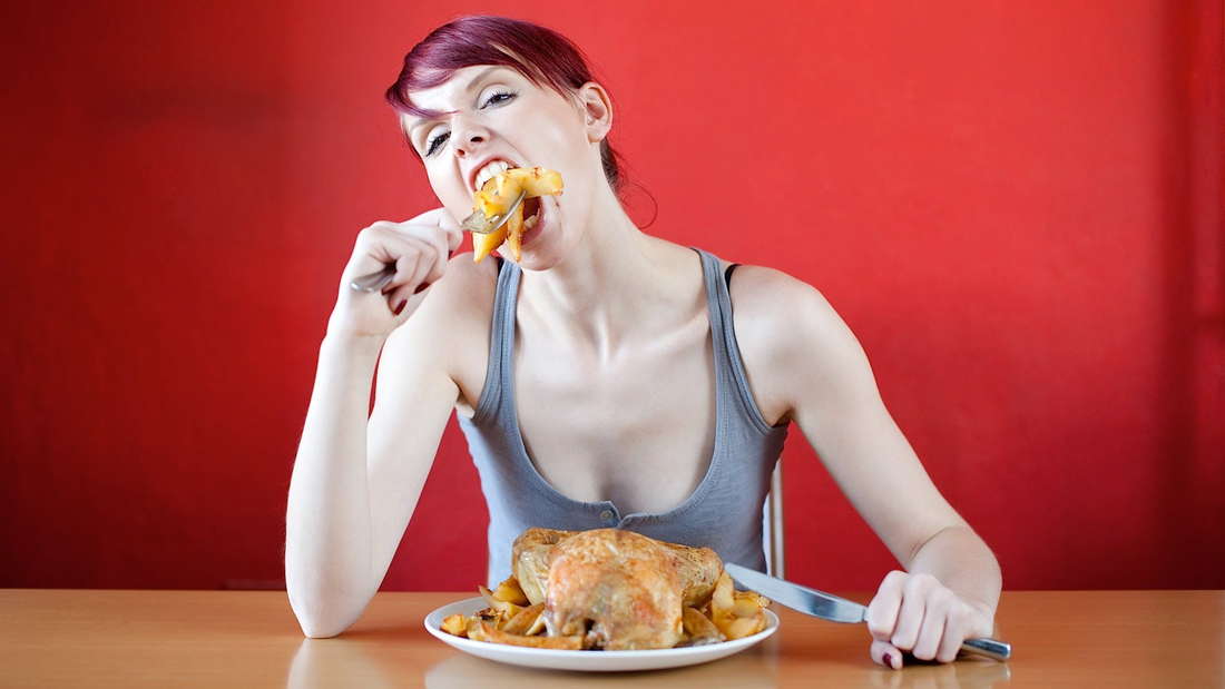 голодная женщина кушает с аппетитом картошку с мясом