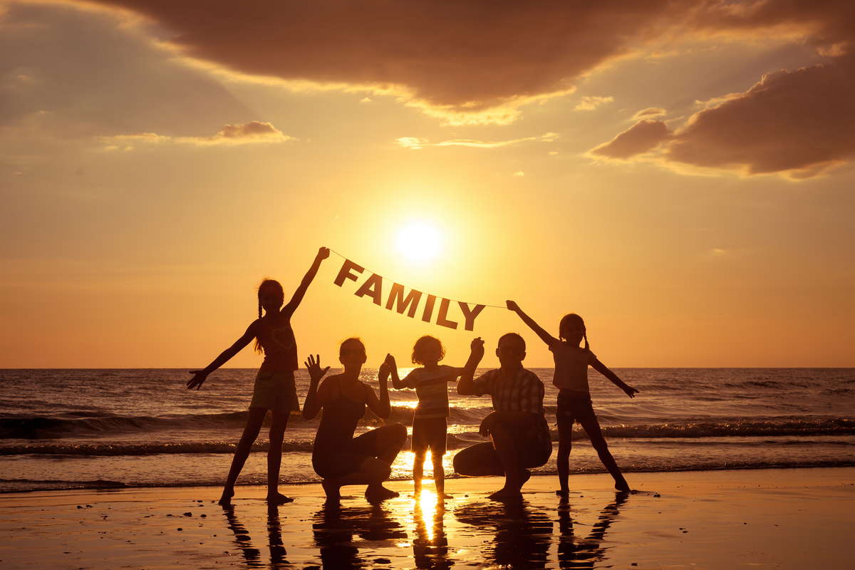счастливая семья на закате на пляже