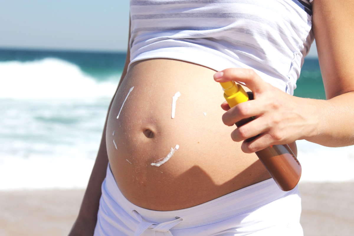 Нанесение солнцезащитного крема во время беременности на пляже