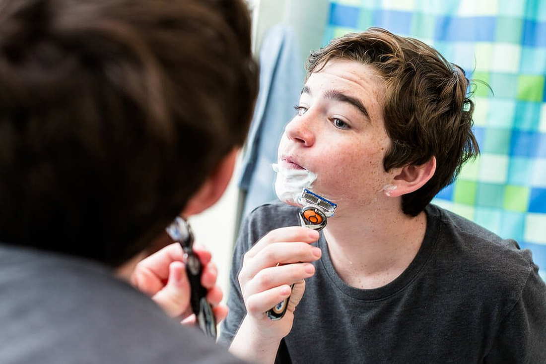 мальчик подросток бреется перед зеркалом